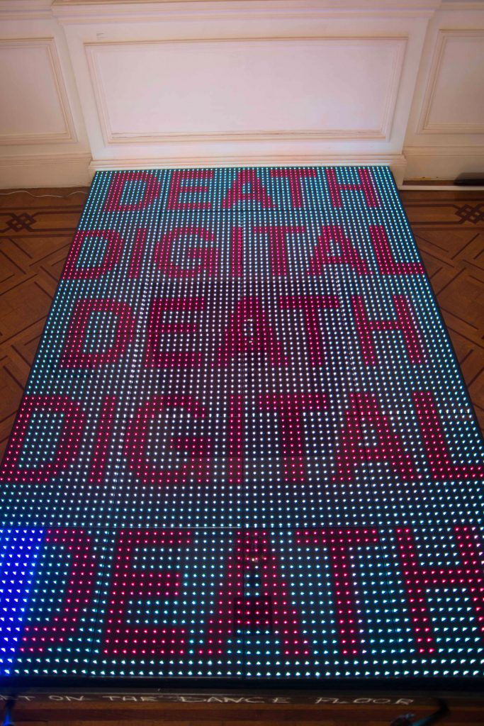 Filip Markiewicz We have the disco in order not to die from the truth, 2015, mixed media installation with neon light dancefloor, video, drums, variable dimensions, unique. Courtesy of Aeroplastics contemporary.